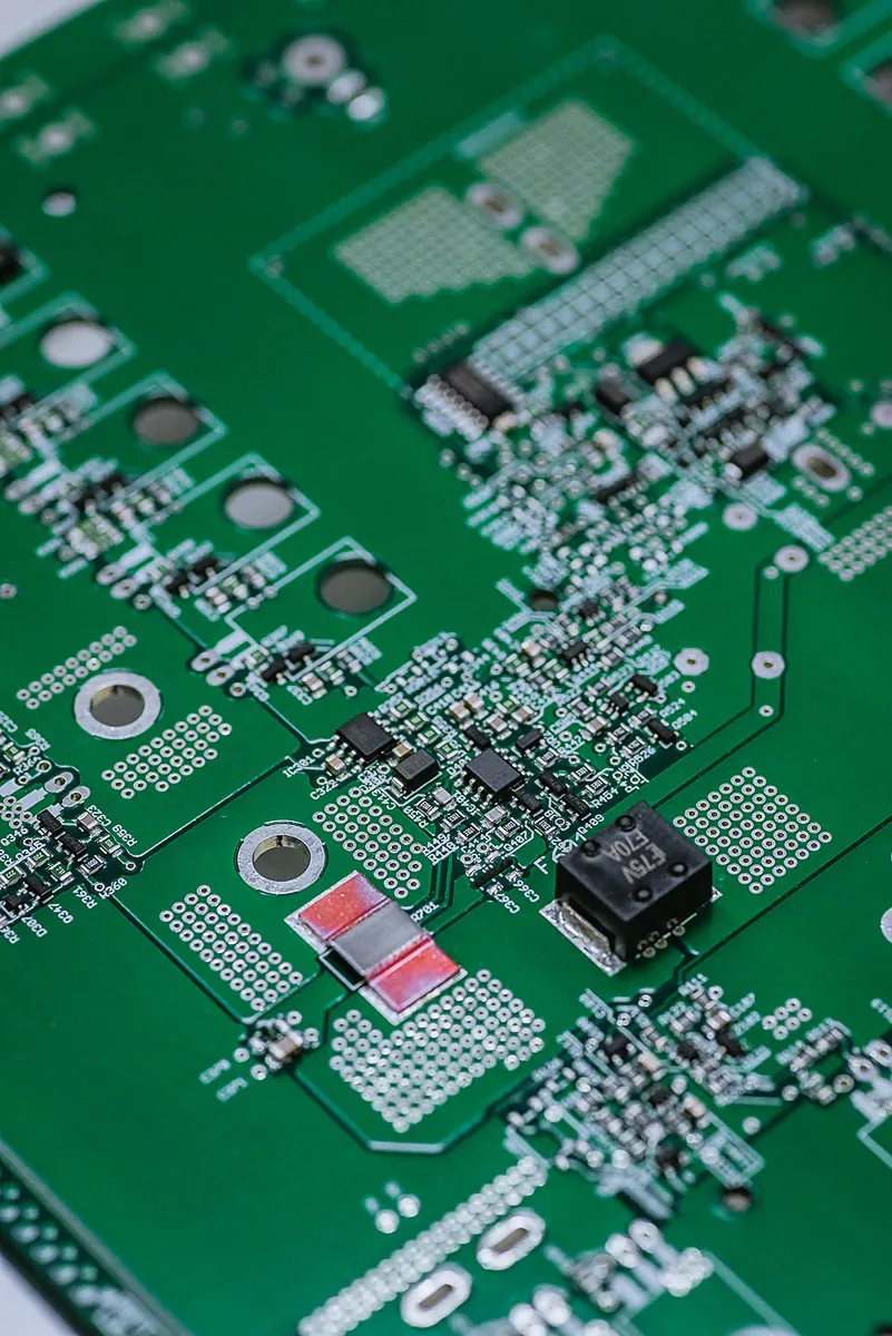 Close-up of a green printed circuit board with surface-mount components