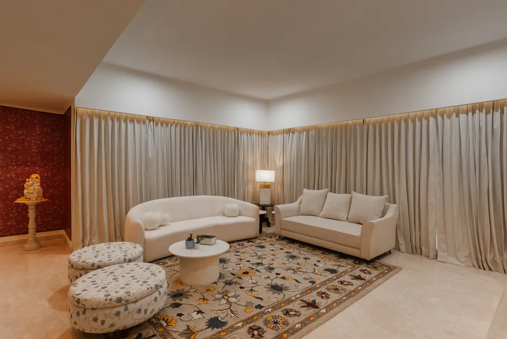 Formal living room with curved cream sofas, round ottomans and a floral rug
