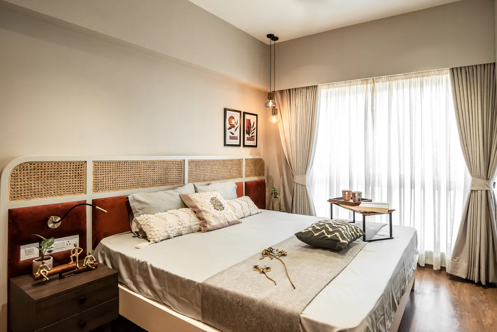 Bedroom with a cane headboard, layered bedding and sheer curtains